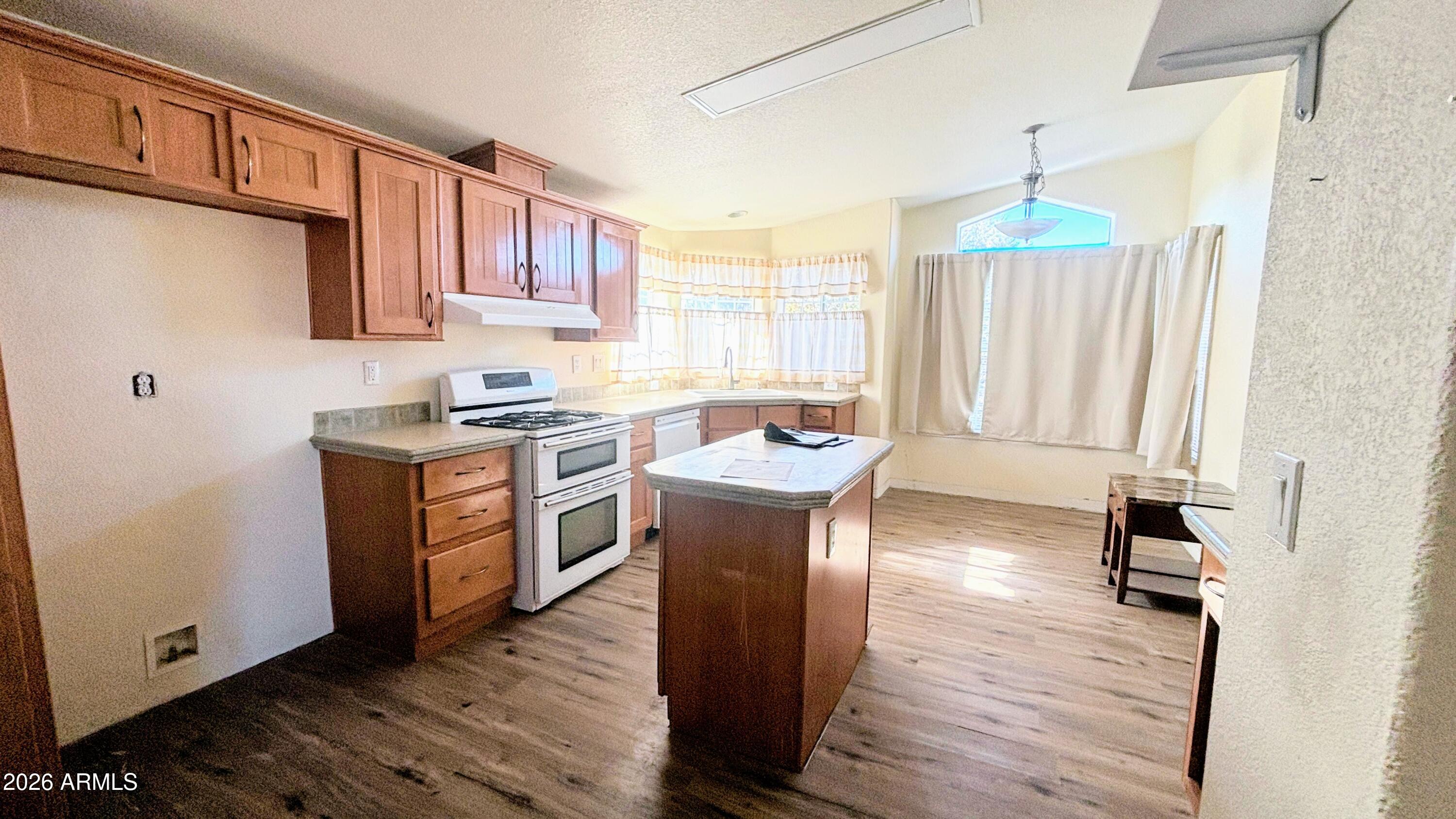 111 County Road, Unit 8015 Show Low, AZ 85901 - Photo 8 of 34 a kitchen with stainless steel appliances granite countertop a stove a sink dishwasher and a refrigerator with wooden floor