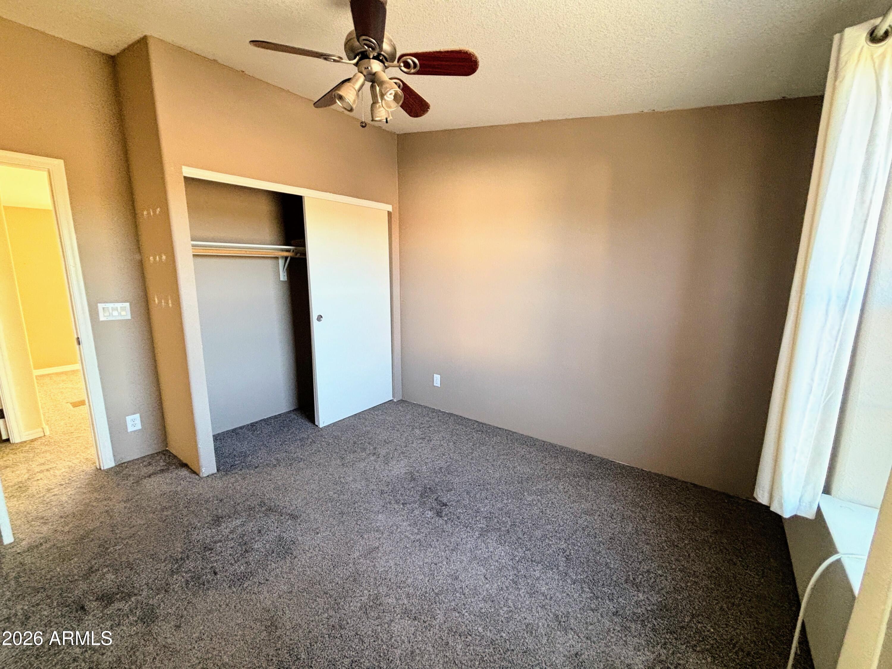 111 County Road, Unit 8015 Show Low, AZ 85901 - Photo 10 of 34 an empty room with closet and a ceiling fan