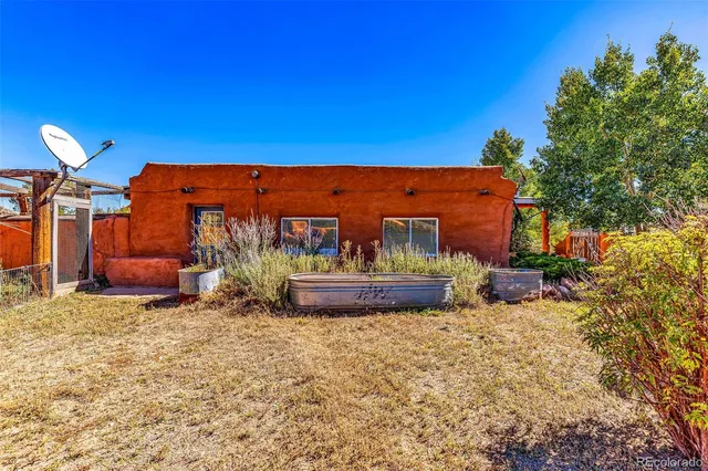 a view of a chairs and fire pit in the backyard in front of house