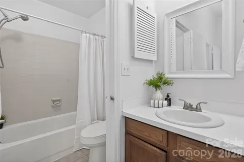 a bathroom with a granite countertop sink a toilet and shower