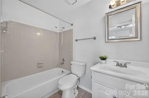 a bathroom with a granite countertop toilet a sink and bathtub