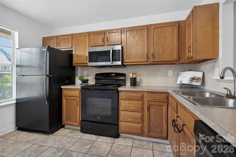 a kitchen with stainless steel appliances granite countertop a refrigerator stove and sink