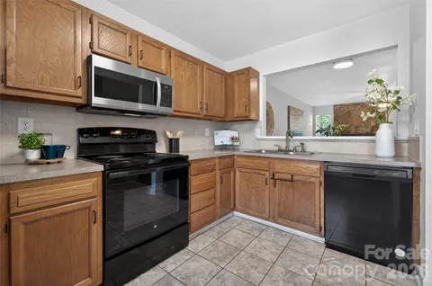 a kitchen with stainless steel appliances granite countertop a sink and a stove top oven