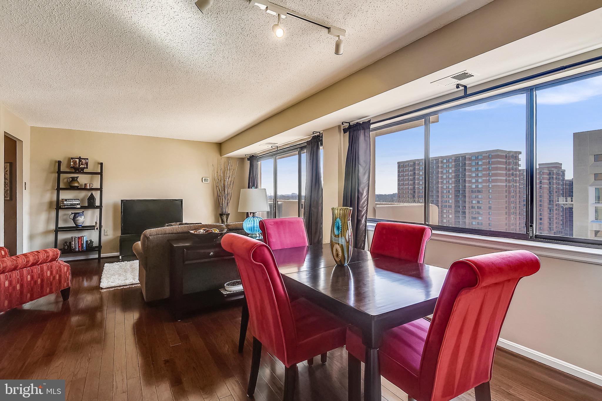 1301 North Courthouse Road, Unit 1503 Arlington, VA 22201 - Photo 11 of 26 a view of a dining room with furniture large windows and wooden floor