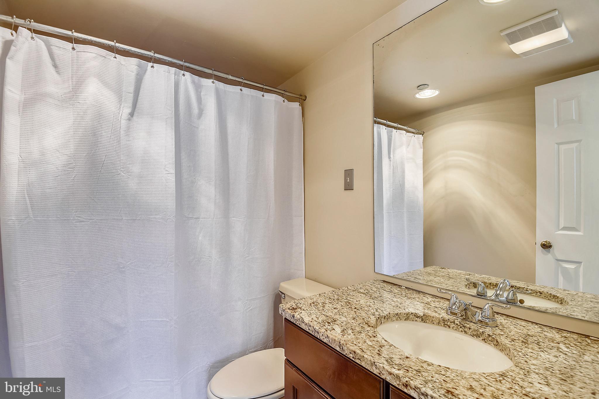 1301 North Courthouse Road, Unit 1503 Arlington, VA 22201 - Photo 7 of 26 a bathroom with a granite countertop sink and a mirror