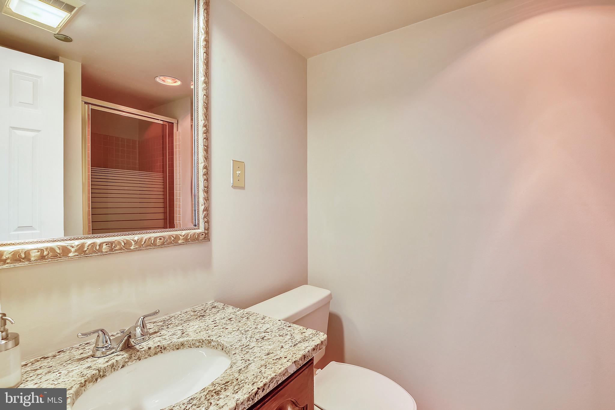 1301 North Courthouse Road, Unit 1503 Arlington, VA 22201 - Photo 9 of 26 a bathroom with a granite countertop sink and a mirror