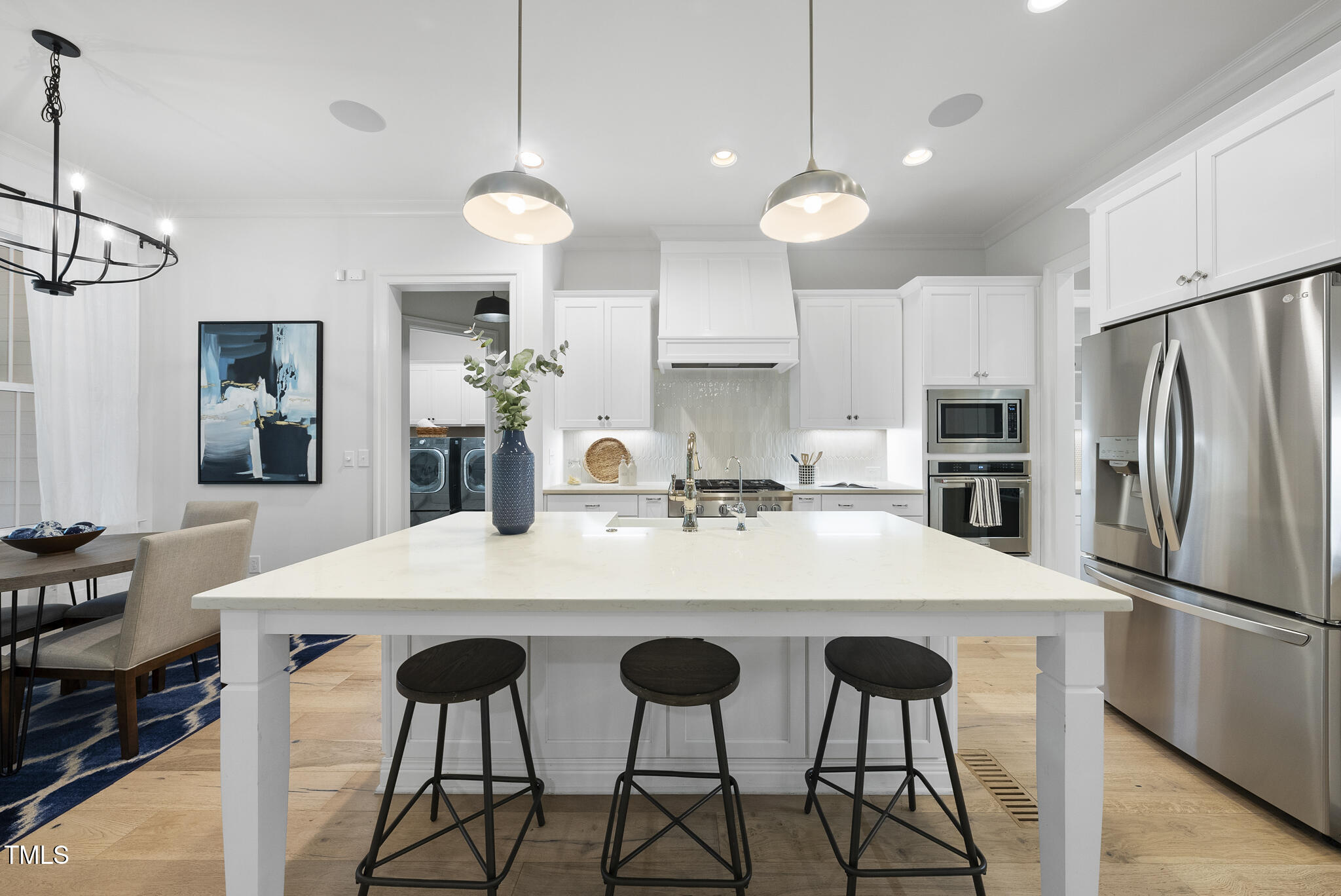 2073 Amalfi Place Apex, NC 27502 - Photo 9 of 40 a kitchen with stainless steel appliances a table and chairs in it