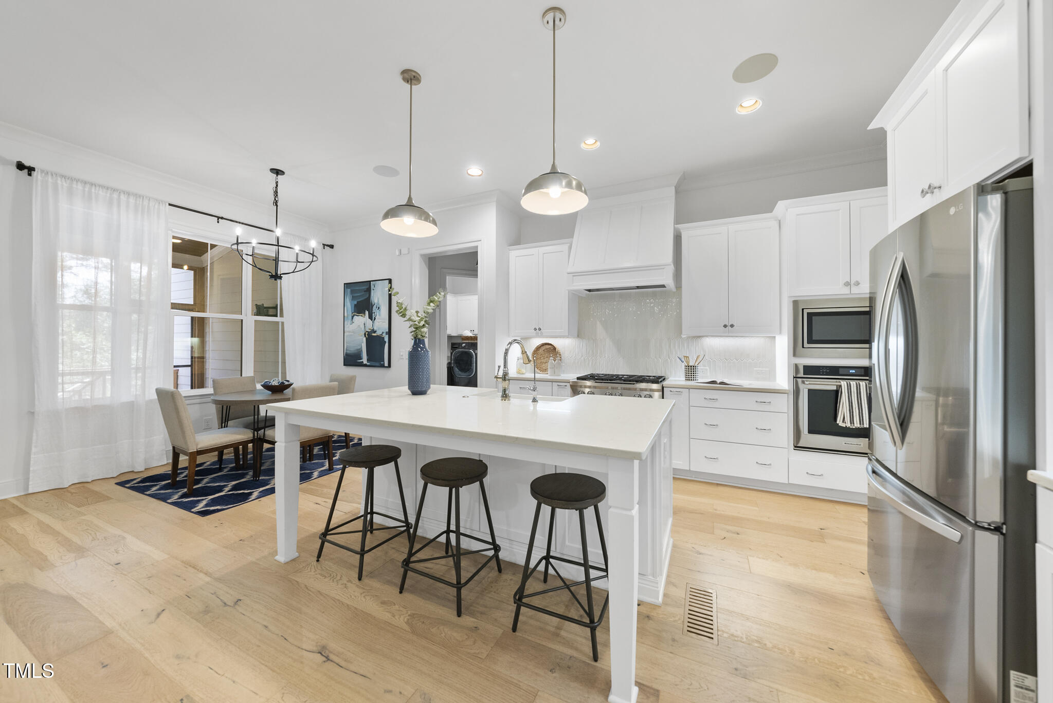 2073 Amalfi Place Apex, NC 27502 - Photo 10 of 40 a kitchen with stainless steel appliances granite countertop a sink a stove a refrigerator cabinets and chairs