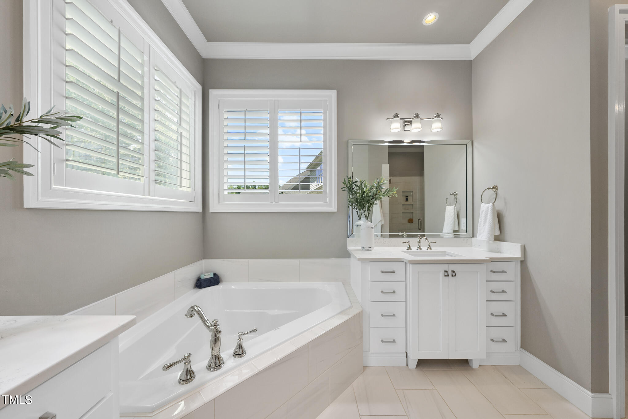 2073 Amalfi Place Apex, NC 27502 - Photo 21 of 40 a bathroom with a tub sink and mirror