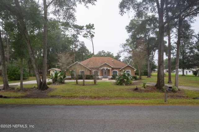 a front view of a house with a yard and trees