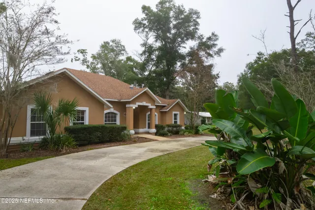 a front view of a house with a yard and trees