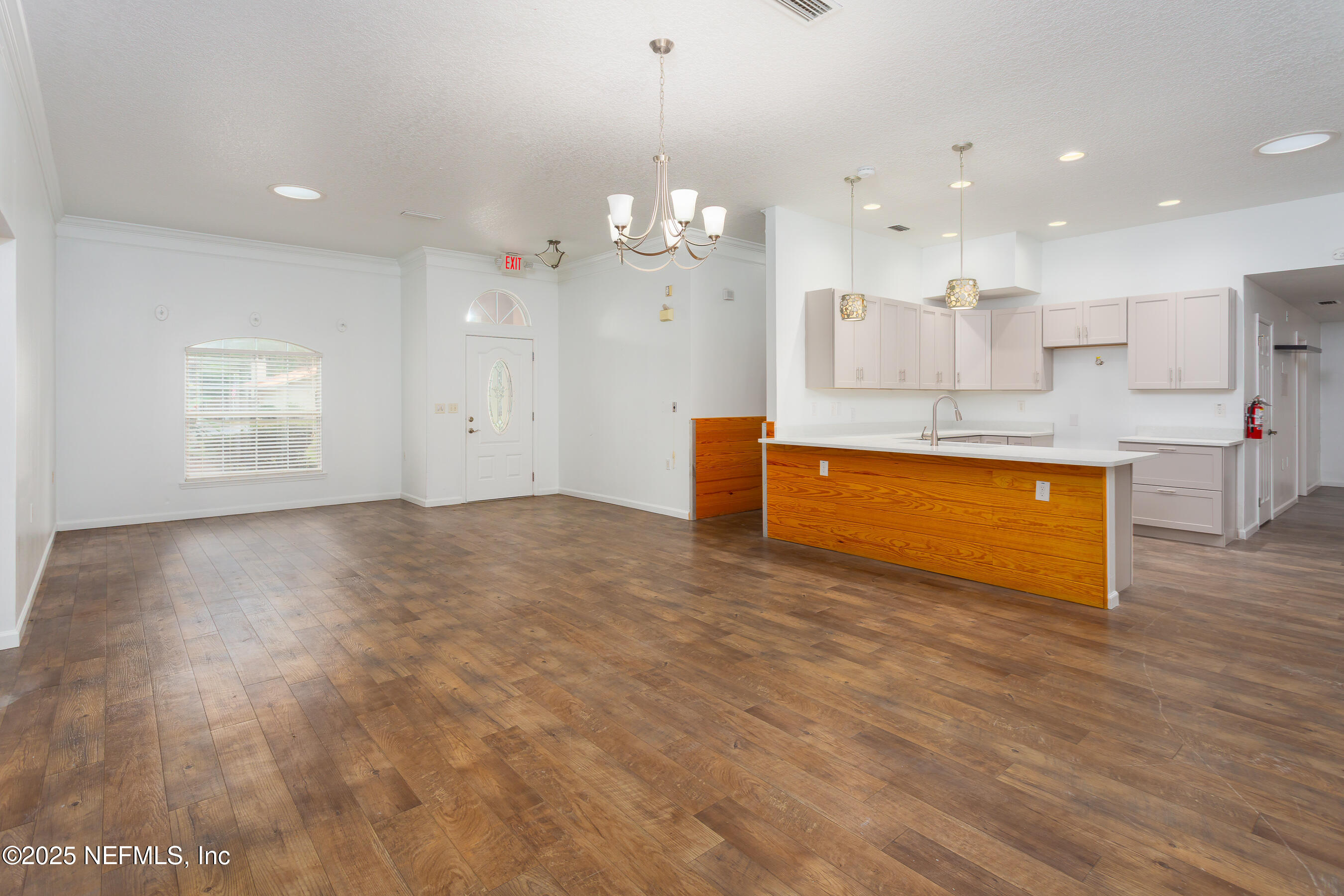164 Carole Road Palatka, FL 32177 - Photo 4 of 32 a view of kitchen and empty room with wooden floor and windows