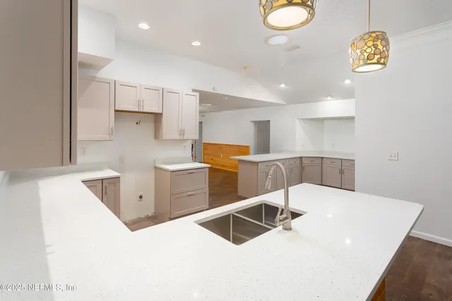 a kitchen with stainless steel appliances a white counter top space cabinets and a window