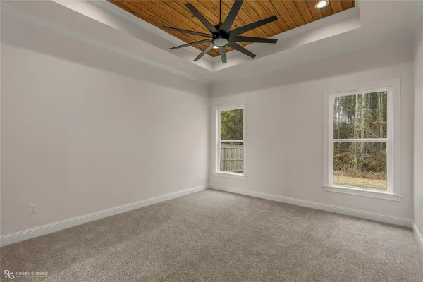 an empty room with windows and fan