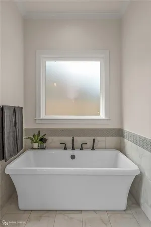 a bathroom with a bathtub and a window