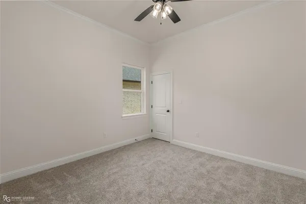 an empty room with a ceiling fan and window