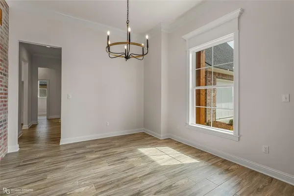 a view of empty room with wooden floor and window
