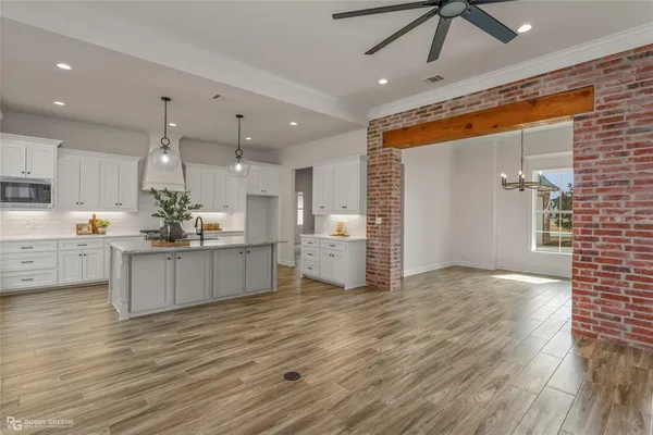 a large kitchen with kitchen island a sink stainless steel appliances and cabinets