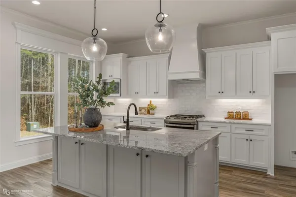a kitchen with granite countertop a sink a counter space appliances and cabinets