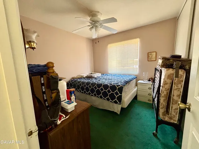 a bedroom with a bed and dresser with mirror