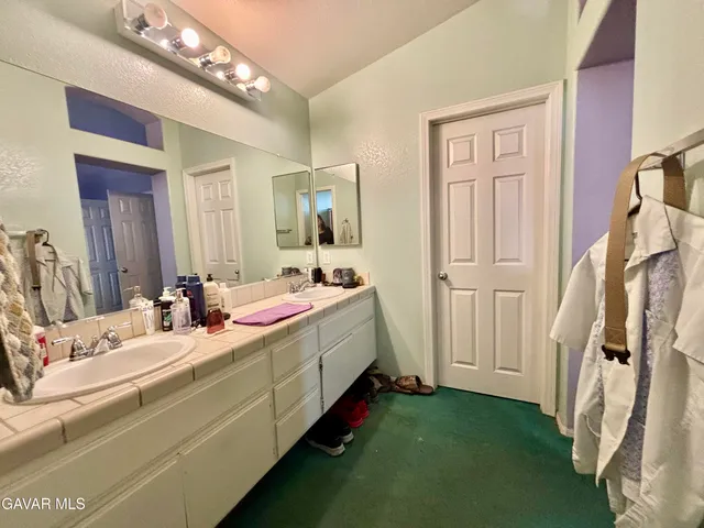 a bathroom with a sink a mirror and a shower curtain