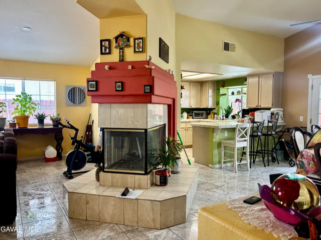a living room with furniture a fireplace and a floor to ceiling window