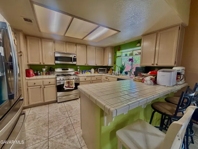 a kitchen with a sink a counter top space appliances and cabinets