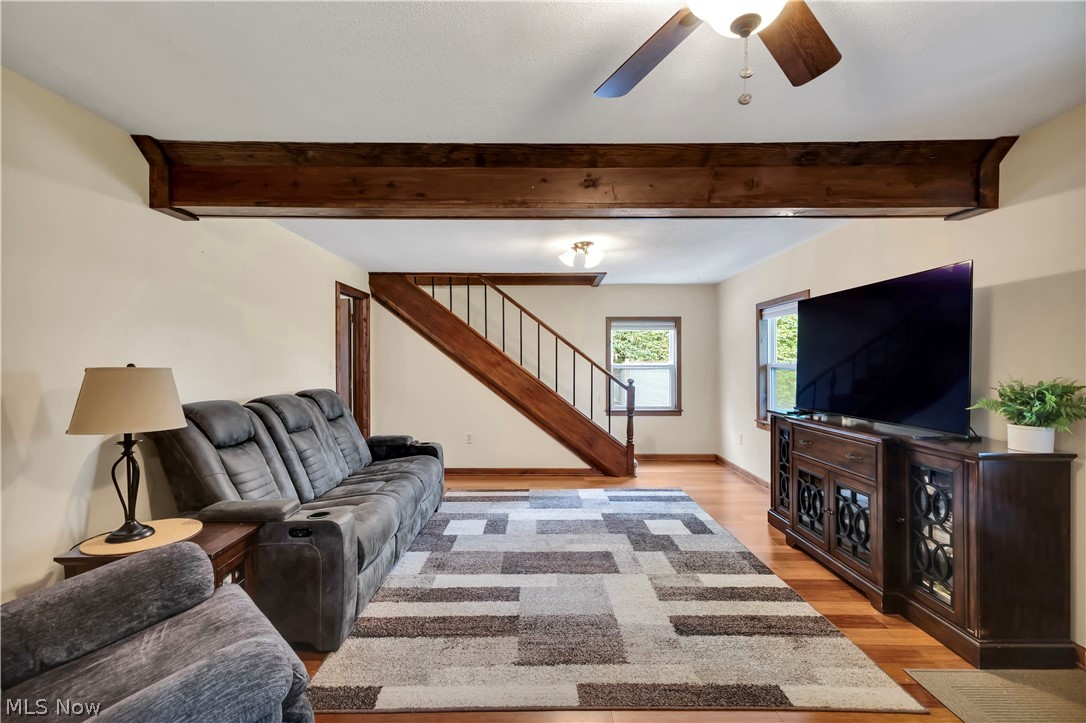 8704 Columbia Road Olmsted Falls, OH 44138 - Photo 10 of 34 Living area featuring wood-finish flooring, exposed ceiling beams, and a ceiling fan with light fixture