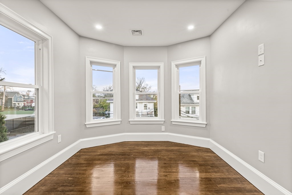 1 Claymont Terrace Boston, MA 02122 - Photo 21 of 42 a view of an empty room with wooden floor and a window