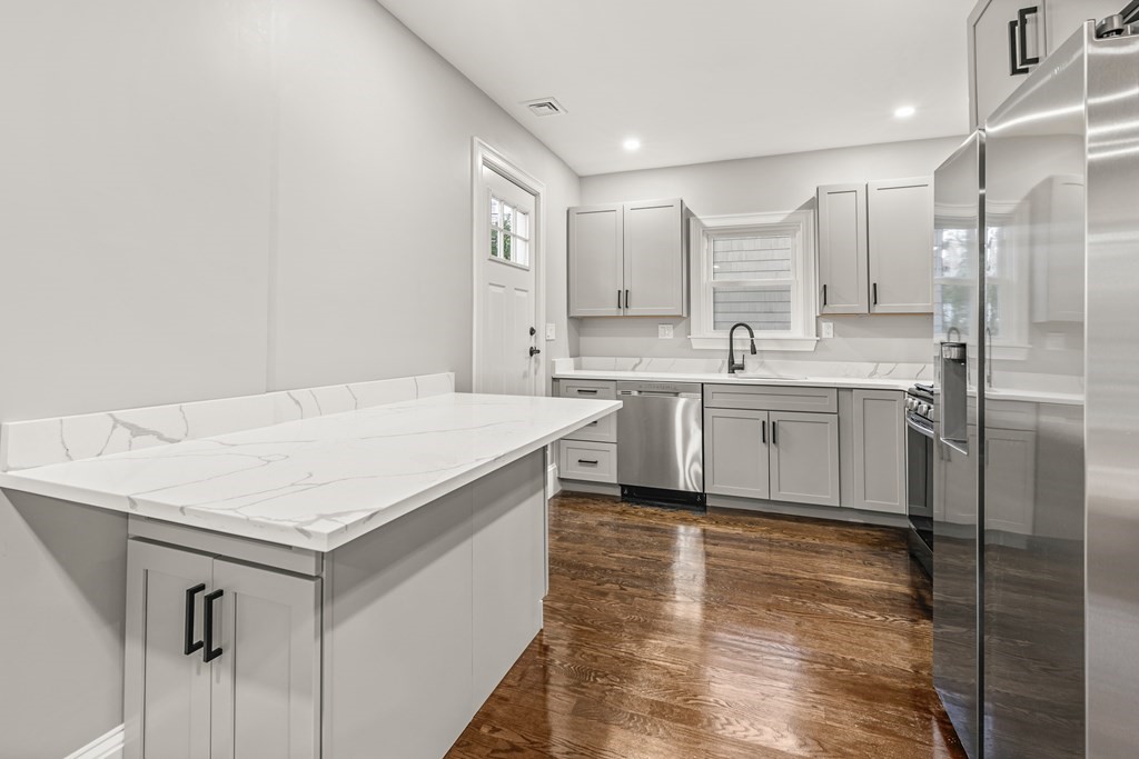 1 Claymont Terrace Boston, MA 02122 - Photo 27 of 42 a kitchen with a sink stainless steel appliances and white cabinets