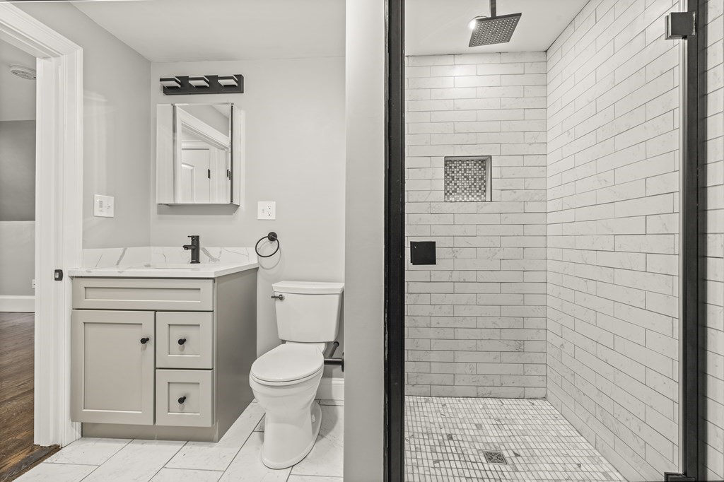 1 Claymont Terrace Boston, MA 02122 - Photo 35 of 42 a bathroom with a toilet a sink a shower and mirror