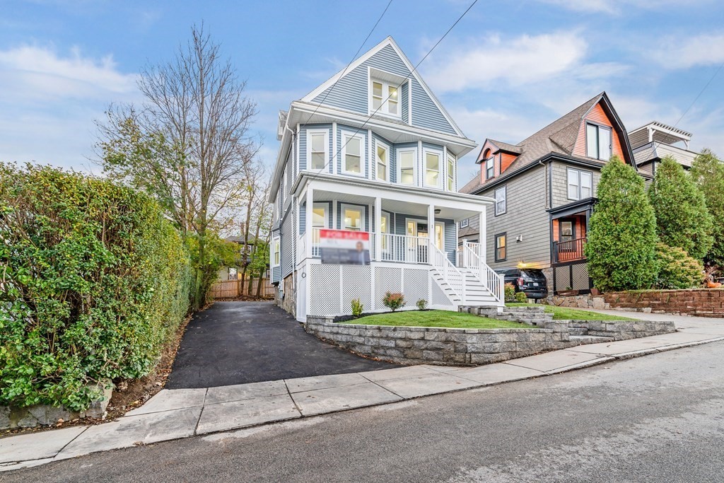 1 Claymont Terrace Boston, MA 02122 - Photo 6 of 42 a front view of a house with a yard and garage
