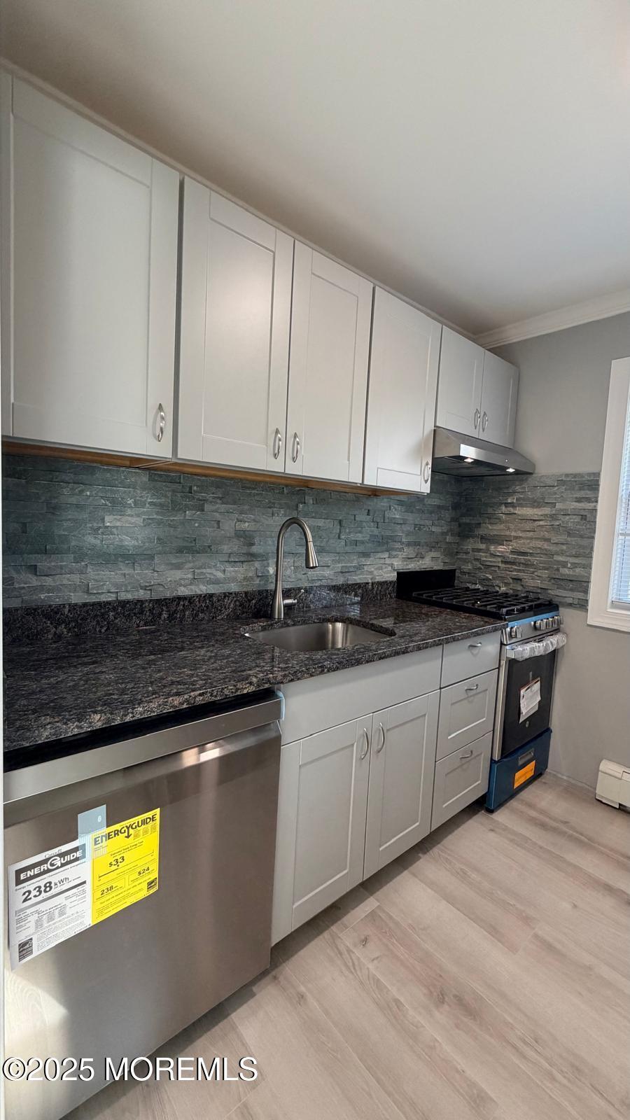 420 Cross Road, Unit B16 Matawan, NJ 07747 - Photo 5 of 29 a kitchen with stainless steel appliances granite countertop a sink stove and cabinets