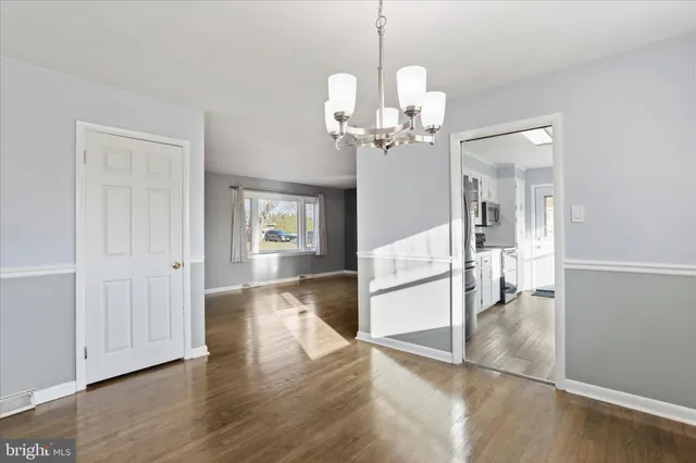 a view of a livingroom with a furniture wooden floor and chandelier