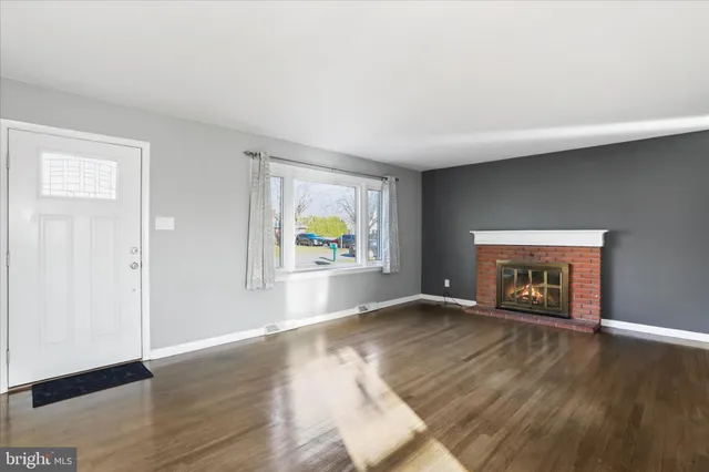 an empty room with wooden floor and a window