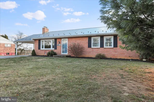 a front view of house with yard and trees around