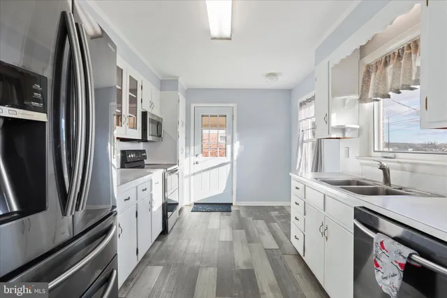 a kitchen with stainless steel appliances a sink stove refrigerator and cabinets