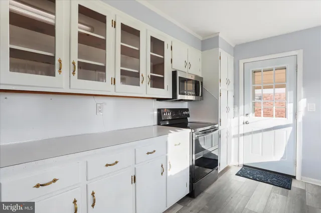 a kitchen with stainless steel appliances granite countertop white cabinets and window
