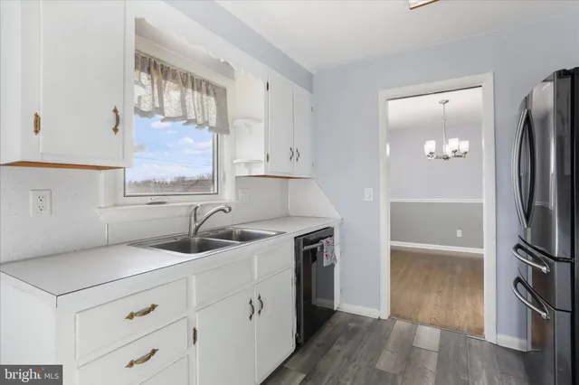 a kitchen with a refrigerator sink and cabinets