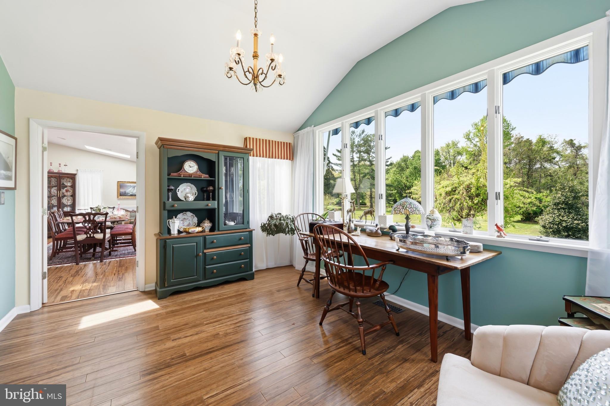 24561 Deepwater Point Drive St. Michaels, MD 21663 - Photo 21 of 50 a dining room with wooden floor a chandelier a wooden table and chairs