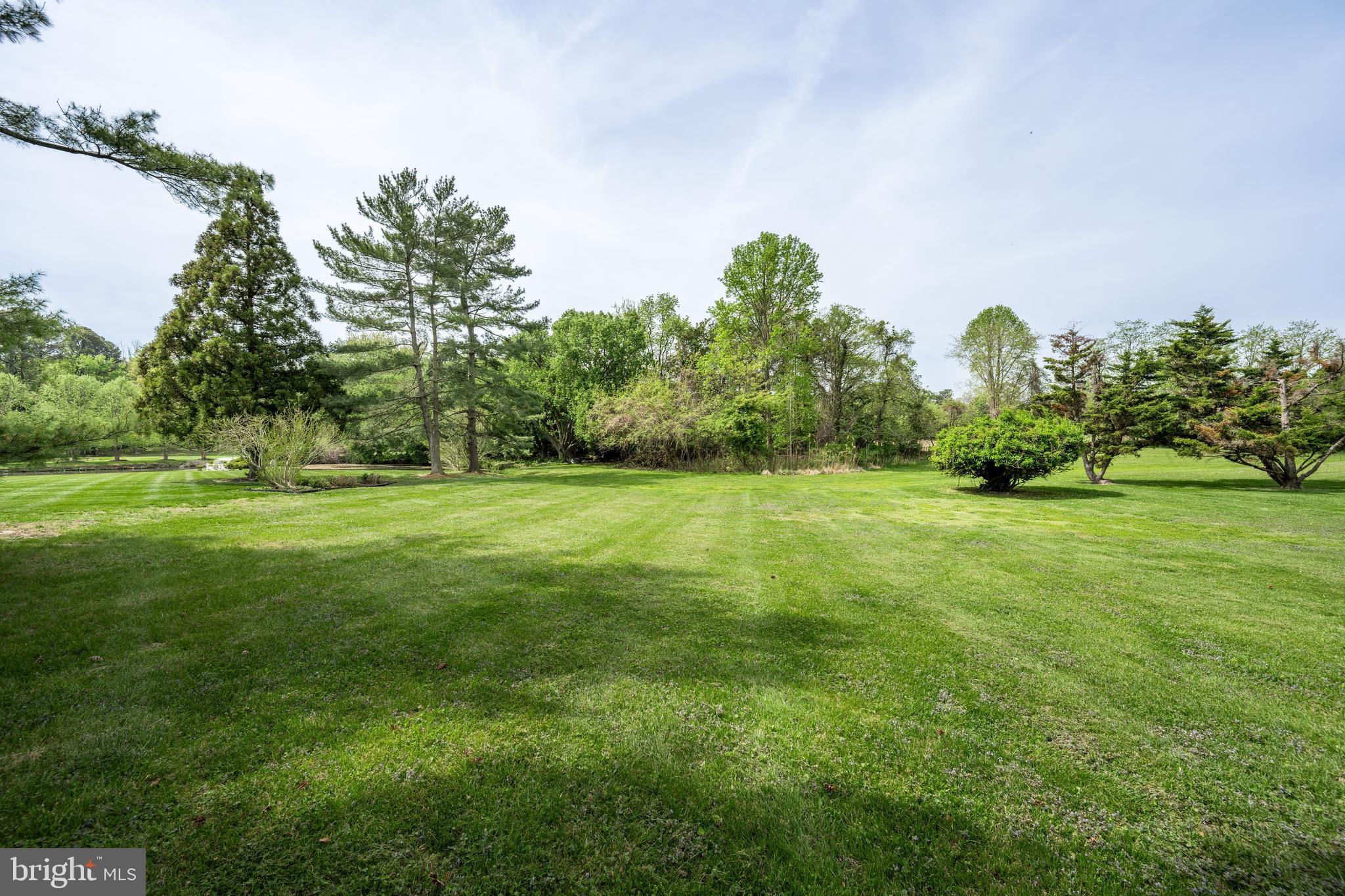 24561 Deepwater Point Drive St. Michaels, MD 21663 - Photo 40 of 50 a backyard of a house with lots of green space and fountain