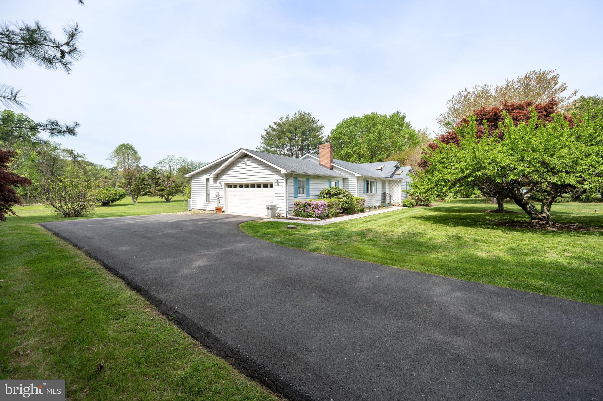 24561 Deepwater Point Drive St. Michaels, MD 21663 - Photo 6 of 50 a front view of a house with a yard and garage