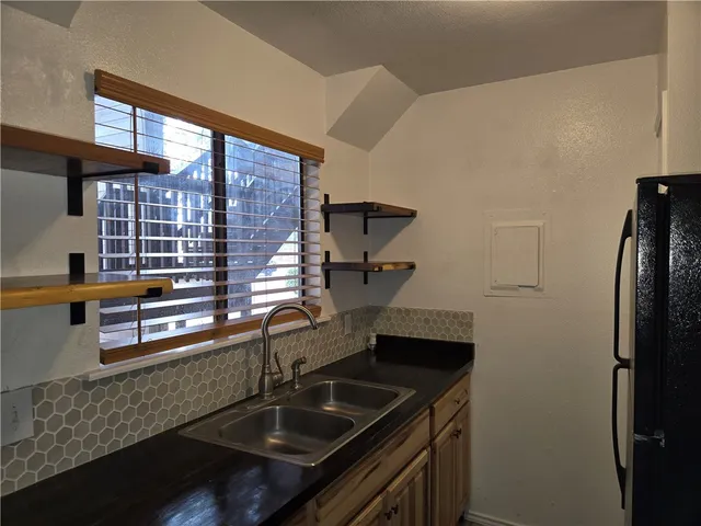 a kitchen with stainless steel appliances granite countertop a sink and a refrigerator