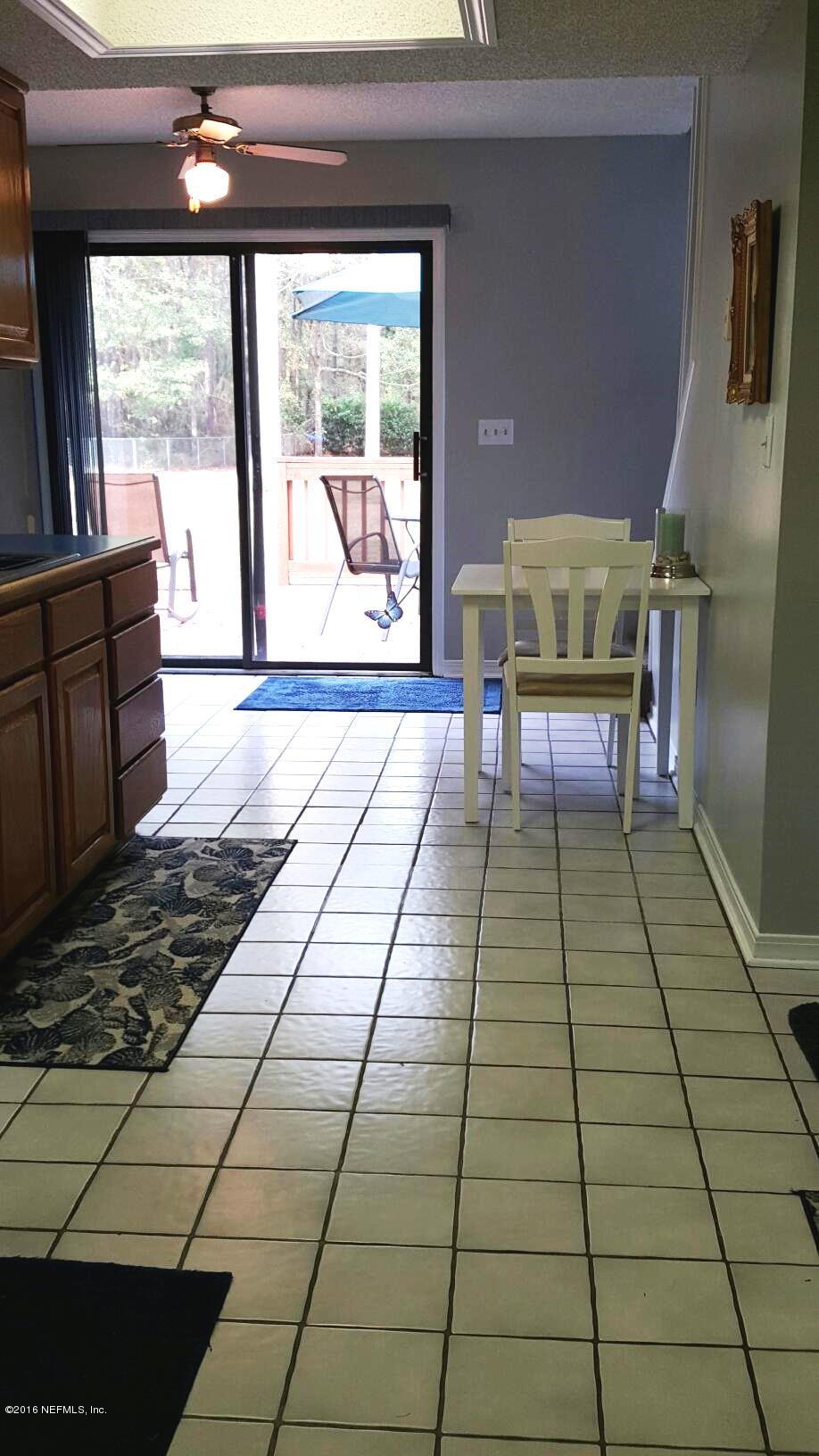 1112 Cactus Cut Road Middleburg, FL 32068 - Photo 15 of 48 a living room with a black white checkered floor next to a yard