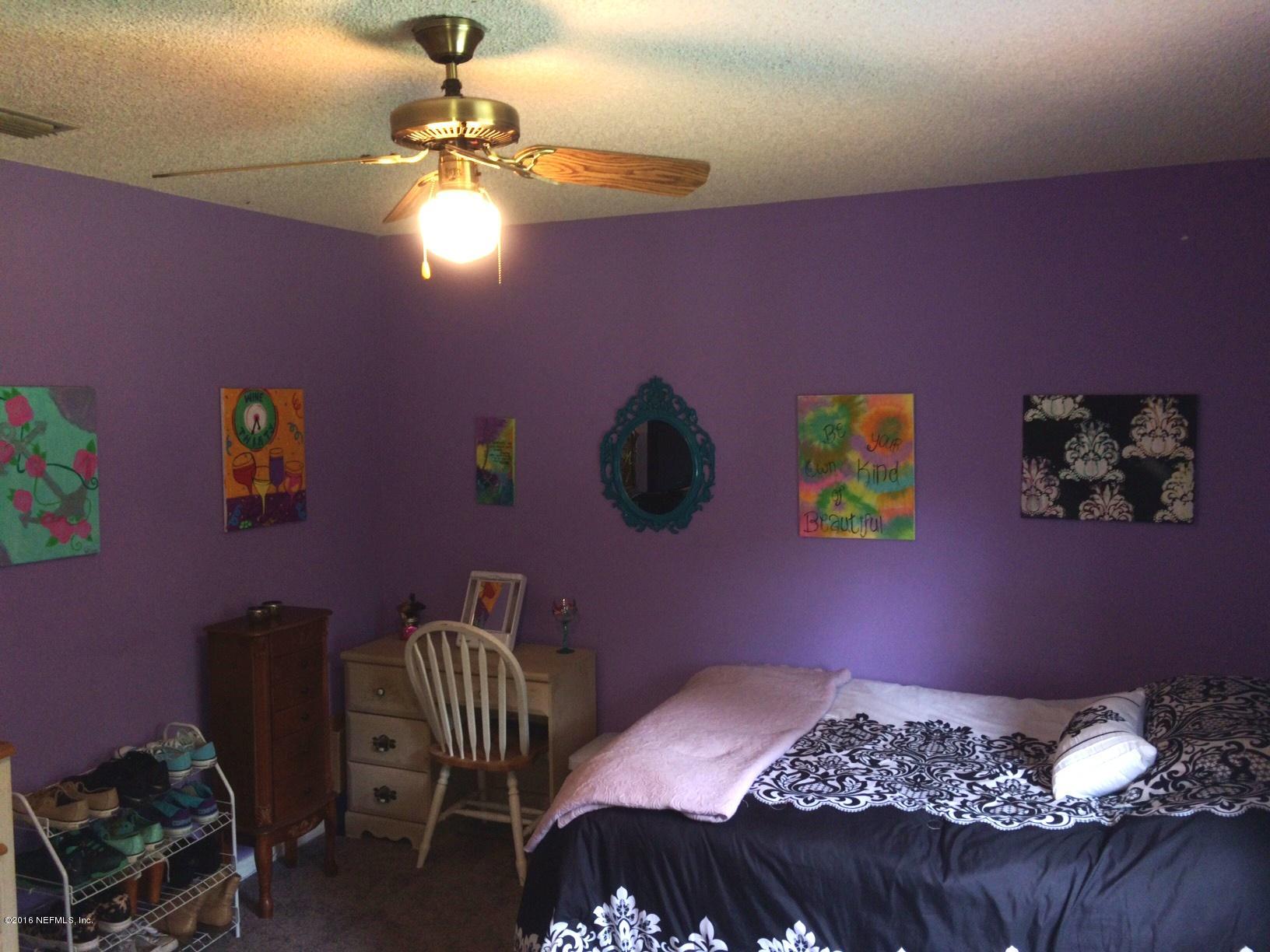 1112 Cactus Cut Road Middleburg, FL 32068 - Photo 26 of 48 a bedroom with a bed and a chandelier