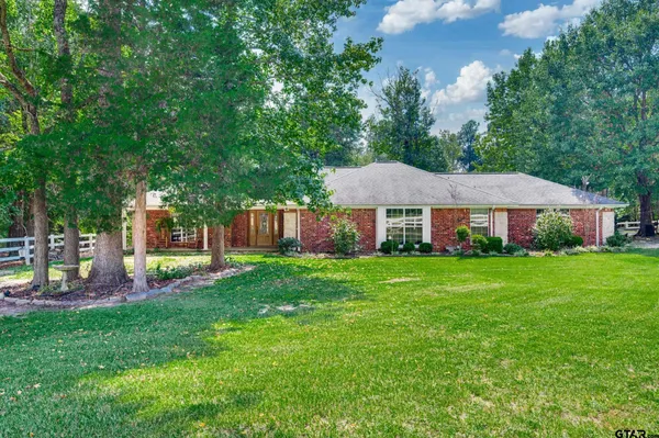 a view of a house with a backyard and a patio