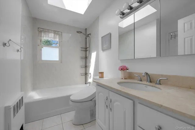 a bathroom with a granite countertop sink a toilet and shower