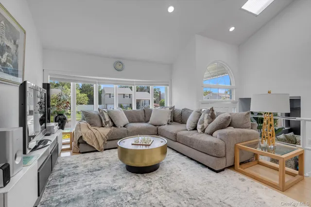 a living room with furniture a large window and a flat screen tv