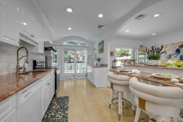 a large kitchen with stainless steel appliances lots of counter space and a sink