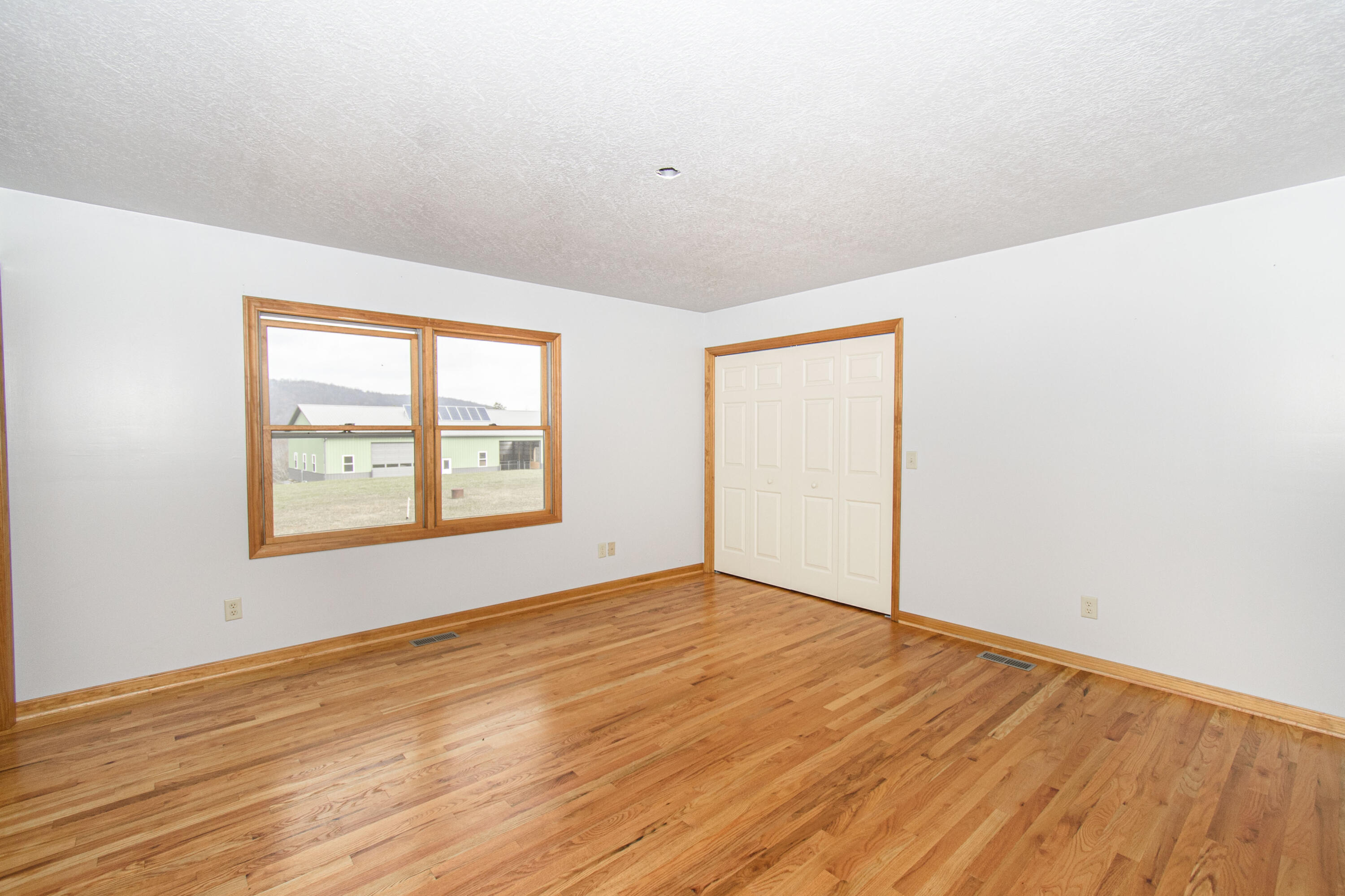 5485 Buffalo Mountain Road Southwest Willis, VA 24380 - Photo 30 of 77 an empty room with wooden floor and windows